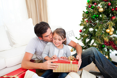 父亲在给她一个圣诞节后亲吻他的小女儿