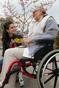 关爱残疾人关爱摄影照片_坐在轮椅上的年轻女子和一位年长的女士