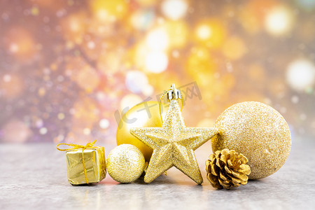 散焦照明背景上的金色圣诞装饰品。