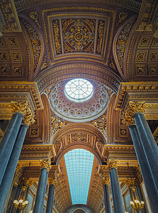 装饰品摄影照片_凡尔赛宫大厅内的玻璃天花板和金色装饰品的建筑细节，伟大的战斗画廊，太阳王路易十四城堡中最大的房间