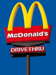 澳大利亚凯恩斯 - 12 月 2 日：2010 年 12 月 3 日在澳大利亚凯恩斯，蓝天背景下的麦当劳标志和得来速标志。