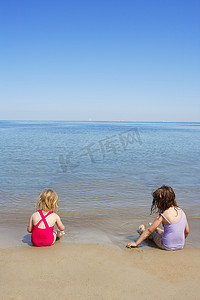 沙滩上的孩子摄影照片_拖姐坐在沙滩泳衣泳衣上