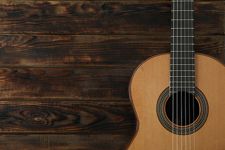 弦摄影照片_木质背景上漂亮的六弦古典吉他，文字空间