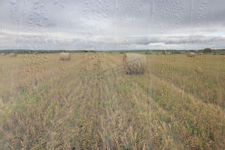 金秋雨后的农田，湿玻璃后面的天空中有云。