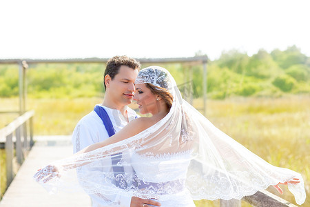 头纱摄影照片_新婚夫妇头纱上有风