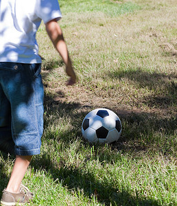 踢足球的小男孩摄影照片_踢足球的小男孩