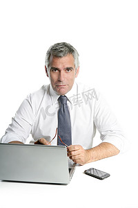 高级行政人员摄影照片_商人高级灰色头发工作笔记本电脑