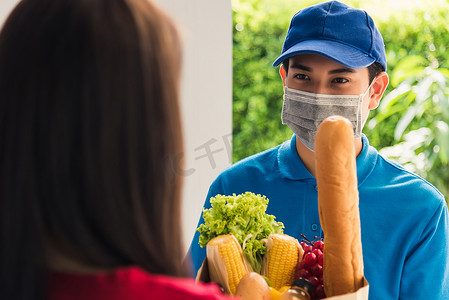 送货员戴防护面罩做杂货店，给女顾客送新鲜食物