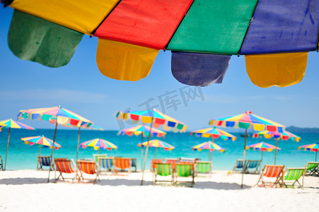 在五颜六色的伞下的沙滩椅在海滩普吉岛，