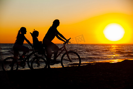 妈妈和孩子剪影摄影照片_母亲和她的孩子骑自行车剪影