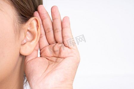 手绘猫耳朵摄影照片_“女性听力损失或听力障碍，手放在耳朵后面，在白色背景下隔离，聋人概念。”