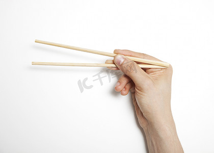 男人的手在白色背景下紧握筷子