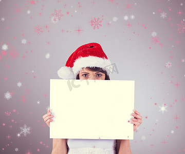 女性红色海报摄影照片_漂亮的圣诞老人女孩用海报对着相机微笑的合成图像