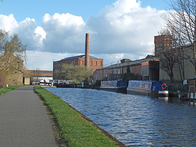 利兹 armley 附近历史悠久的 castleton 磨坊和 oddy lock gates 以及穿过运河的人行天桥和停泊的船屋