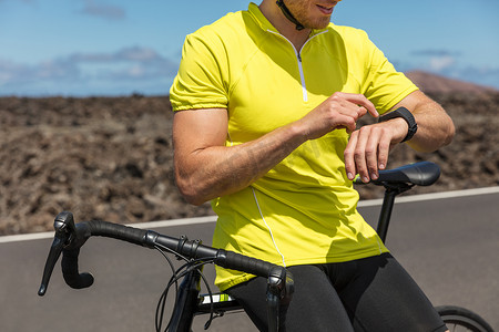 使用健身智能手表在公路自行车上骑自行车的人