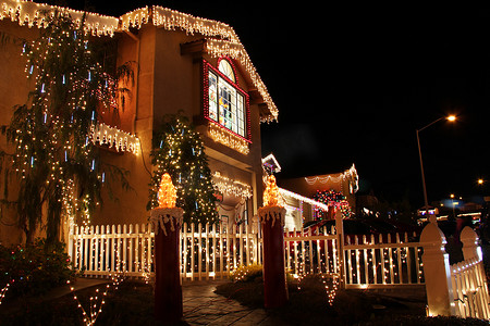 下雪圣诞摄影照片_装饰有圣诞灯饰的房子