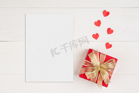 明信片模板摄影照片_空白明信片大小 a5 和信件和礼品盒和木桌上的心形，样机贺卡和模板，装饰浪漫，庆祝情人节和节日概念。
