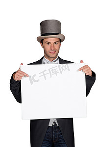 戴着大礼帽和尾巴的男人拿着一块木板，留下空白供您留言