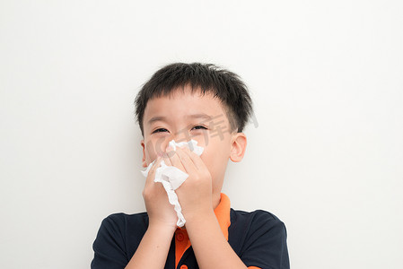 鼻子痒鼻炎摄影照片_亚洲小男孩用薄纸擦鼻子