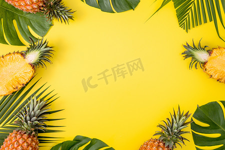 热带棕榈蒙斯特拉叶上的美丽菠萝与明亮的淡黄色背景、顶视图、平躺、头顶上方的夏季水果隔离开来。