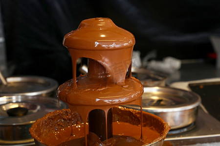 煮火锅摄影照片_关闭甜点的牛奶巧克力喷泉