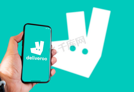 2021 年 4 月，英国伦敦：背景模糊的手机屏幕上的 Deliveroo 徽标