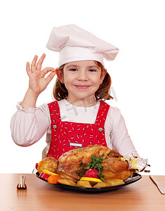漂亮的小女孩用烤鸡做饭