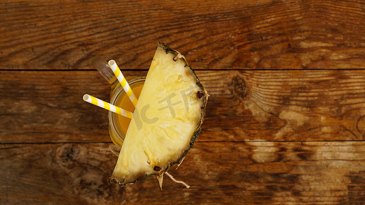 粉色菠萝摄影照片_木制背景上的菠萝汁。