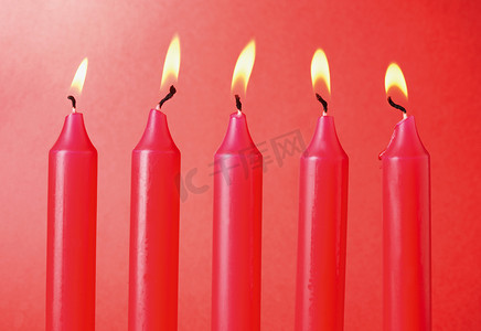 红色背景上的五个红色蜡烛。