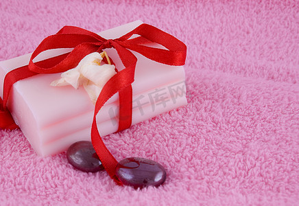 粉色漂浮的花瓣摄影照片_有玫瑰和石头的肥皂