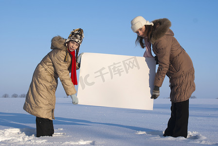 在冬天雪地里拿着白色海报的女孩