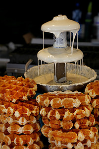 煮火锅摄影照片_关闭比利时薄酥饼和白巧克力喷泉