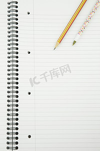 用钢笔和铅笔 o 关闭一个空白的白色内衬记事本