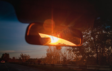 在汽车后视镜内的沙龙里夕阳红的阳光。