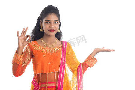 欢快的印度传统年轻女性手拿东西的肖像，在白色背景下手掌上展示复制空间
