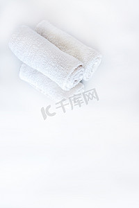洗澡摄影照片_白色干净的毛巾和薰衣草花在白色孤立的背景