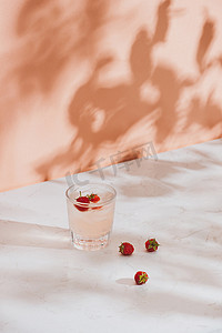浅色背景中玻璃杯中的新鲜覆盆子夏季果汁
