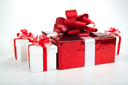 红色礼物盒摄影照片_在灰色的一个红色礼物盒白色礼物盒