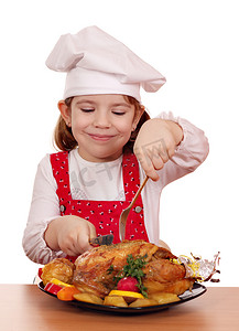 女孩吃鸡摄影照片_小女孩厨师吃烤鸡