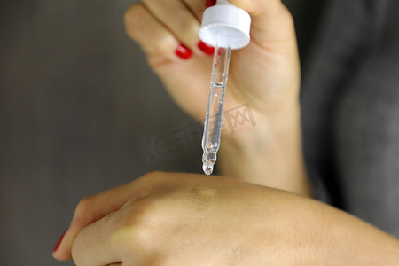 女性手滴血清胶原蛋白保湿霜。