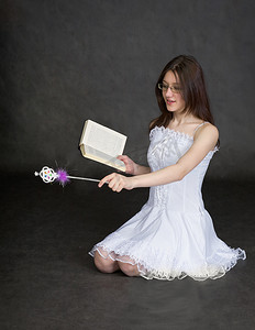 驱魔摄影照片_女孩-手中拿着魔杖和书的仙女
