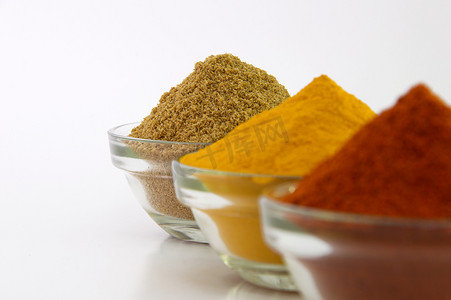 香料粉：白色背景中孤立的碗中的辣椒、姜黄和香菜。