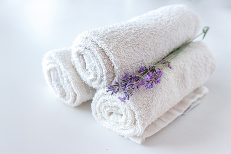洗澡摄影照片_白色干净的毛巾和薰衣草花在白色孤立的 backgr