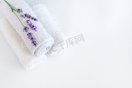 洗澡摄影照片_白色干净的毛巾和薰衣草花在白色孤立的背景