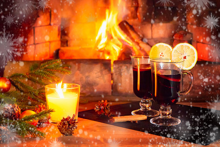 树支摄影照片_两杯热红酒，一支蜡烛，冷杉树枝，木桌上有装饰品，背景是燃烧的壁炉，周围是白霜和雪花。