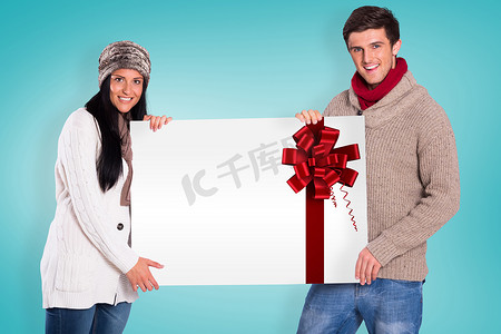 圣诞节合成海报摄影照片_拿着海报的年轻夫妇的合成图象