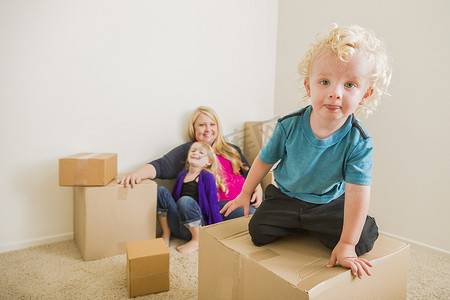 年轻的家庭在空房间里玩移动箱子