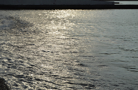 海卵石滩上闪闪发亮的银色水，清晨的日出