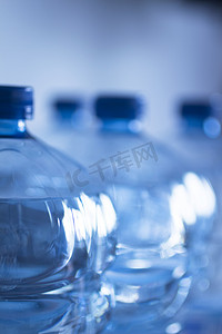 塑料水瓶摄影照片_孤立的塑料水瓶蓝色背景工作室