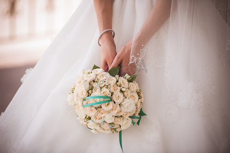 捧花摄影照片_新娘手捧白玫瑰的婚礼花束